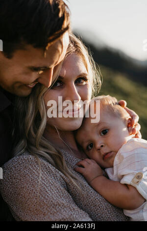 Portrait de famille affectueuse avec peu de fils à l'extérieur Banque D'Images