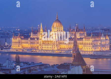 Assis sur les rives du Danube, le Parlement hongrois bâtiment construit en style néo-gothique, l'UNESCO, Budapest, Hongrie Banque D'Images