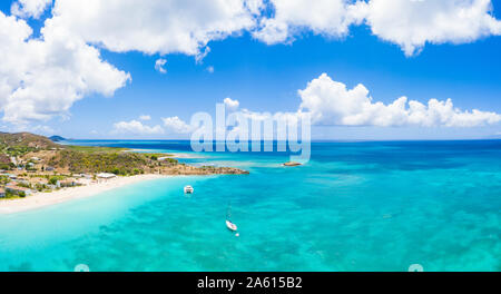 Vue panoramique aérienne par drone de bateaux dans la mer des Caraïbes bleu approchant pour aménagement de plage, Antigua, Antigua et Barbuda, Iles sous le vent, West Indies Banque D'Images