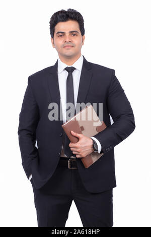 Portrait of handsome young businessman holding journal. Certains hommes debout sur fond blanc. Il porte un costume élégant. Banque D'Images