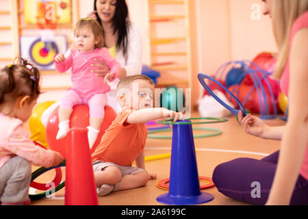 Formation de groupe avec des mamans bébés in gym Banque D'Images