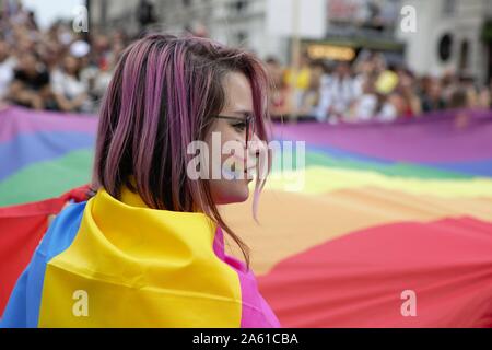 Jeune gardien enveloppé dans un drapeau de la fierté au cours de la parade.Le 50ème Pride Parade toke lieu à travers le centre de Londres avec plus d'un million de participants. Banque D'Images