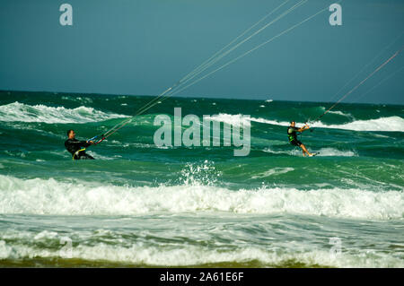 Paire de kite surfeurs dans une mer et vagues de la côte Atlantique à Argelès-sur-Mer, France. Banque D'Images