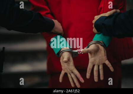 Dniepr, l'Ukraine - 22 octobre 2019 : deux policiers fidèlement arrestation de cosplayeuse dans l'image d'un clown fou Arthur Fleck sur le plan psychologique thril Banque D'Images