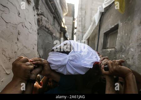 Bureij, Territoires palestiniens. 23 Oct, 2019. Porter le deuil, corps de 17 ans, Imad palestinienne Shahin lors de ses funérailles. Les autorités israéliennes ont libéré mercredi le corps de Shahin, qui est mort de blessures subies au cours d'affrontements alors qu'il aurait été tentant de traverser la frontière Israel-Gaza en novembre 2018. Credit : Mohammed Talatene/dpa/Alamy Live News Banque D'Images