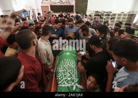 Bureij, Territoires palestiniens. 23 Oct, 2019. Porter le deuil, corps de 17 ans, Imad palestinienne Shahin lors de ses funérailles. Les autorités israéliennes ont libéré mercredi le corps de Shahin, qui est mort de blessures subies au cours d'affrontements alors qu'il aurait été tentant de traverser la frontière Israel-Gaza en novembre 2018. Credit : Mohammed Talatene/dpa/Alamy Live News Banque D'Images