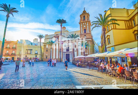 Cadix, Espagne - 19 septembre 2019 : la pittoresque Piazza de la Catedral avec la ligne de cafés en plein air et splendide église de Santiago de l'arrière-plan, sur sept. Banque D'Images