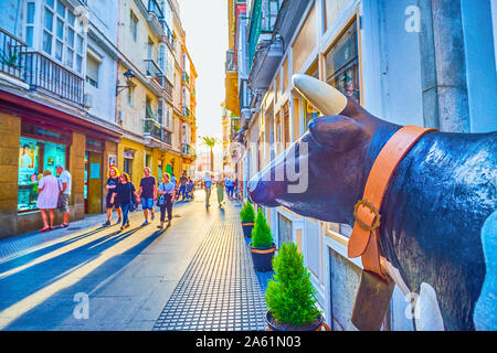 Cadix, Espagne - 19 septembre 2019 : La sculpture de la vache, se situe à l'entrée de la boutique, l'observation de l'activité dans l'étroite shopping Paloma Banque D'Images