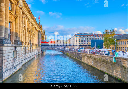 BERLIN, ALLEMAGNE - le 3 octobre 2019 : Le train rouge s'exécute sur le pont de chemin de fer à travers le canal étroit de la rivière Spree conduisant le long de l'île des musées, sur l'Oc Banque D'Images