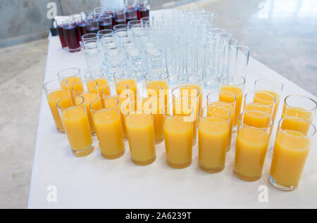 Verres de jus d'orange .Rangée de verres avec du jus d'Orange. Concept de restauration. Flou d'arrière-plan flou. Focus sélectif . Groupe des lunettes avec Banque D'Images