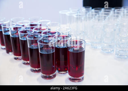 Verres de jus de cerise .Rangée de verres avec du jus de cerise. Concept de restauration. Flou d'arrière-plan flou. Focus sélectif . Groupe des lunettes avec Banque D'Images