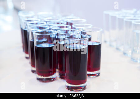 Verres de jus de cerise .Rangée de verres avec du jus de cerise. Concept de restauration. Flou d'arrière-plan flou. Focus sélectif . Groupe des lunettes avec Banque D'Images