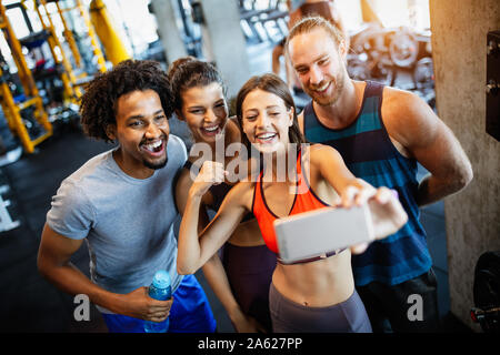 Groupe de sportifs dans une salle de sport en tenant. selfies Concepts de vie et de sport fitness club Banque D'Images