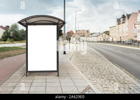 Blanc et vierge maquette isolés panneau d'affiche à l'arrêt de bus dans la grande ville. Une belle journée ensoleillée avec un ciel bleu. Banque D'Images