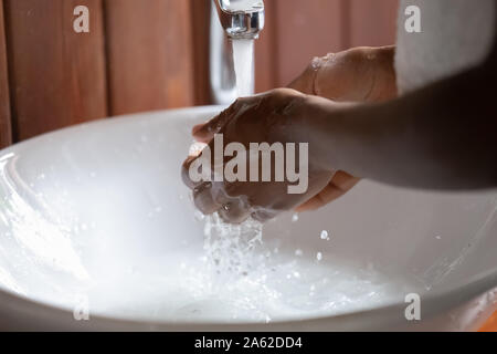 Jeune africain ethnie guy lave-mains à l'eau courante. Banque D'Images