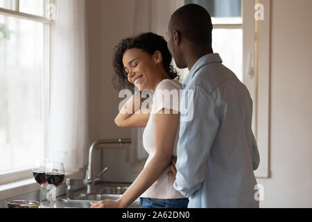 Smiling african american woman taking cheveux loin, à l'écoute de mari. Banque D'Images