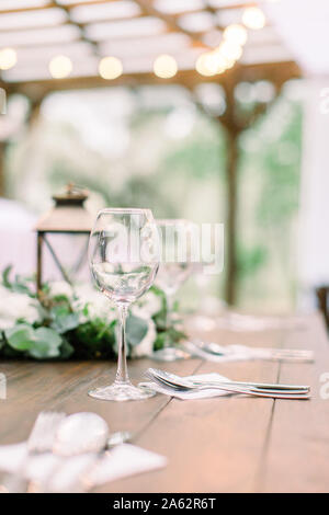 Table rustique avec des décorations florales, des lanternes. Wineglasses sur la table. Mariage ou un dîner en plein air restaurant table Banque D'Images