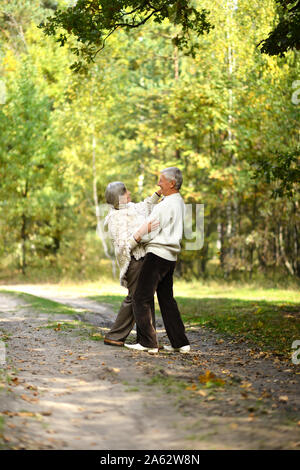 Portrait of a senior couple dancing in autumn forest Banque D'Images