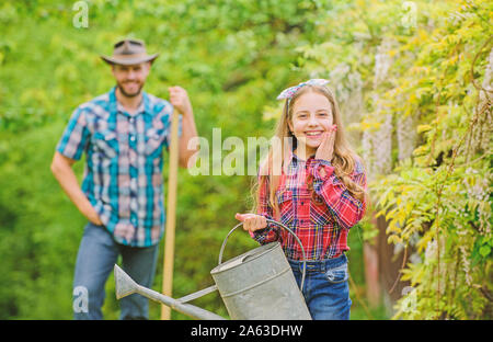 Le repiquage des légumes du centre de jardinage pépinière. Planter des légumes. Saison de plantation. Phases de la lune aident à déterminer le meilleur temps jardin des plantes. Planter des fleurs. Père de famille et sa fille la plantation des plantes. Banque D'Images