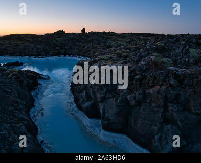 L'eau géothermale entre les roches volcaniques en face du Blue Lagoon en Islande Banque D'Images