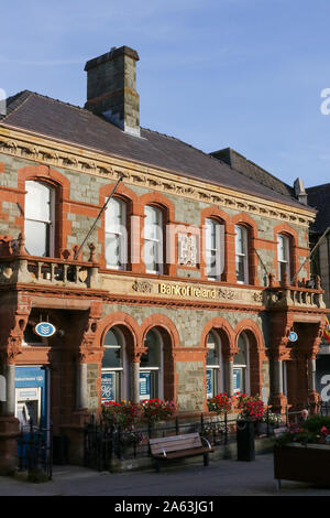 Banque Banque ville ou en Irlande. Homme assis sur le siège à l'extérieur d'une banque en Irlande à la Bank of Ireland, Letterkenny, comté de Donegal. Banque D'Images