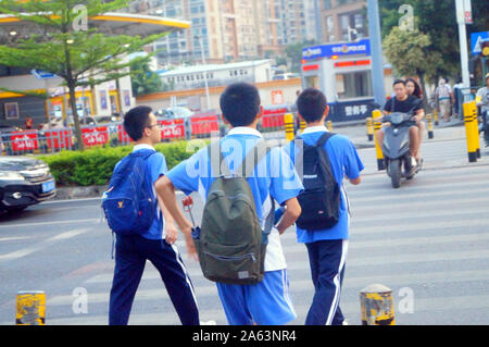 Les élèves de collège chinois à pied à la maison après l'école dans l'après-midi Banque D'Images