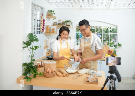 Young Asian Woman cooking together et l'enregistrement de la vidéo en direct de vlog et médias sociaux avec appareil photo professionnel Banque D'Images
