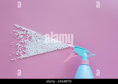 Vaporisateur bleu blanc la pulvérisation de mousse de bulles sur fond rose avec copie espace. creative minime pour concept de nettoyage Banque D'Images