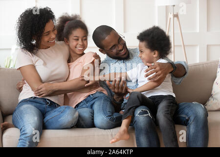 Vous pourrez vous détendre sur la famille black heureux à la maison de la table de câlins Banque D'Images