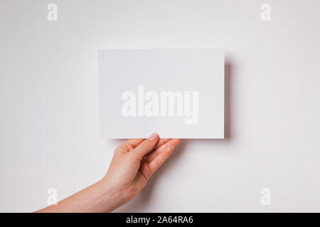 Woman's hand holding blank paper close-up Banque D'Images