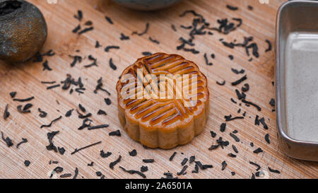 Préparation au concept du festival chinois de la mi-automne. Cuisine traditionnelle pour les vacances délicieux gâteau de lune sur le plateau en bois avec thé pu'er noir. Banque D'Images