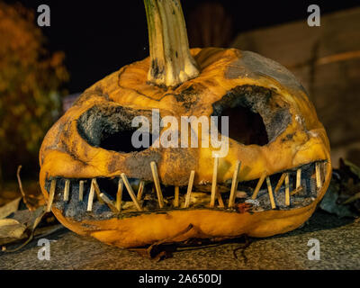 Citrouille sculptée terrible et dessins de lumière colorée à l'arrière-plan, adapté pour l'Halloween Banque D'Images