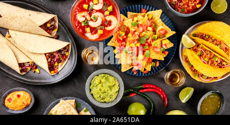 Un panorama de la cuisine mexicaine, de nombreux plats de la cuisine du Mexique, flatlay, tourné par le haut sur un fond noir. Guacamole nachos, tequila, etc. Banque D'Images