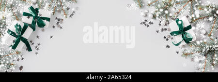 Bannière de Noël avec l'arbre de Noël et cadeaux blanc avec ruban de velours vert sur fond gris. Joyeux Noël carte. Maison de vacances d'hiver. Bonne Année. Spa Banque D'Images
