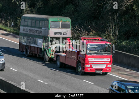 DAF CF towing old rusty barn trouver double decker bus se déplaçant sur l'autoroute M6 près de Preston dans le Lancashire, Royaume-Uni Banque D'Images