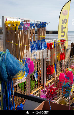 Jouets de plage colorés, seaux et pique, filets de pêche, balles de plage Windrills et beignets à vendre à un Stall dans Scarborough Yorkshire Angleterre Royaume-Uni Banque D'Images