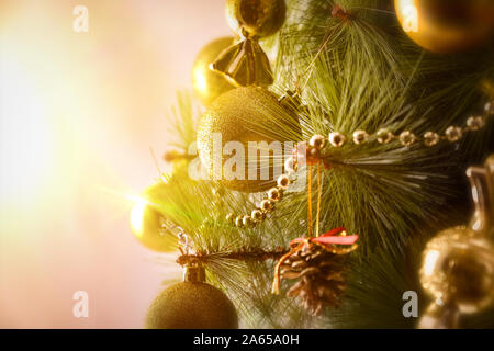 Détail de l'arbre de Noël décoré avec des ornements d'or illuminé par une lumière chaude de flash. Composition horizontale. Vue avant Banque D'Images