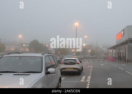 Kidderminster, UK. 24 octobre, 2019. Météo France : tôt le matin le brouillard est lent à soulever dans le Worcestershire, parcs d'activités ont leur éclairage de rue sur l'éclairage d'une Haze misty qui pèse sur un shopping park à Kidderminster. Credit : Lee Hudson/Alamy Live News Banque D'Images