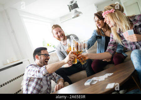 Groupe d'amis se détendre et passer du temps ensemble tout en jouant aux cartes Banque D'Images