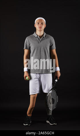 Portrait de jeunes handicapés sportsman dans les vêtements de sports de raquette et de poser à la caméra au-dessus de fond noir Banque D'Images