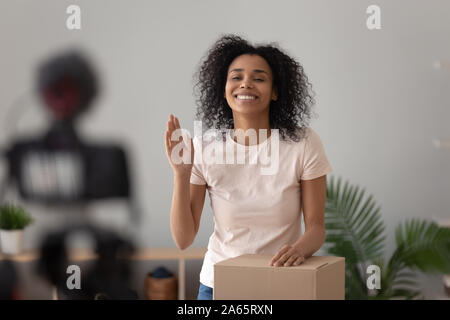 Smiling girl biracial tourner une vidéo déballage blog Banque D'Images