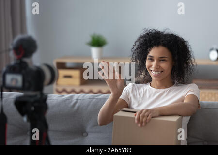 Smiling black girl tournage vlogger sur caméra vidéo de déballage Banque D'Images