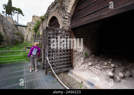 Ercolano. L'Italie. Site archéologique d'Herculanum. Des touristes posent pour vos autoportraits squelettes avec dans les bateaux sur l'ancien rivage. Banque D'Images