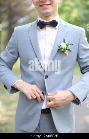 Young smiling groom wearing costume gris. Banque D'Images