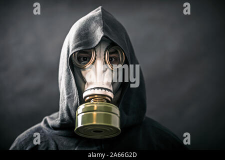 Homme dans un manteau à capuchon et masque à gaz. La pollution de l'environnement. Banque D'Images