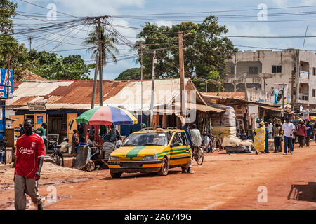 Une longue scène de rue à Serrekunda en Gambie, Afrique de l'Ouest. Banque D'Images