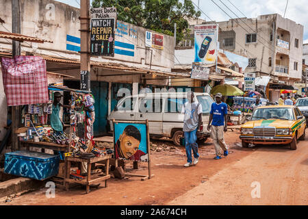 Une longue scène de rue à Serrekunda en Gambie, Afrique de l'Ouest. Banque D'Images