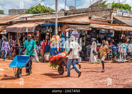 Une longue scène de rue à Serrekunda en Gambie, Afrique de l'Ouest. Banque D'Images