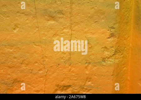 La texture d'un mur peint la plaque de ciment. fond de couleur jaune. mur avec bosses et petits trous. Banque D'Images