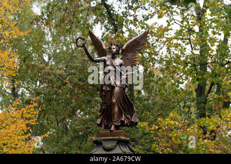 16 octobre 2019, le Brandebourg, Bernau : la déesse de la victoire sur son piédestal Viktoria se trouve en face d'arbres du parc de la ville. Le mémorial de la figure ailée avec Victor's Wreath est érigée près de la muraille de la ville en 1890 selon les plans du sculpteur Friedrich Thiele. Le socle porte l'inscription 'leurs braves guerriers de la glorieuse campagne de 1864, 1866 et 1870/71. En reconnaissant la reconnaissance. La ville de Bad'. Elle commémore l'honneur des soldats de la frontière germano-danoise, Prussian-Austrian et guerres franco-allemand. Photo : Soeren Stache/dpa-Zentralbild/ZB Banque D'Images